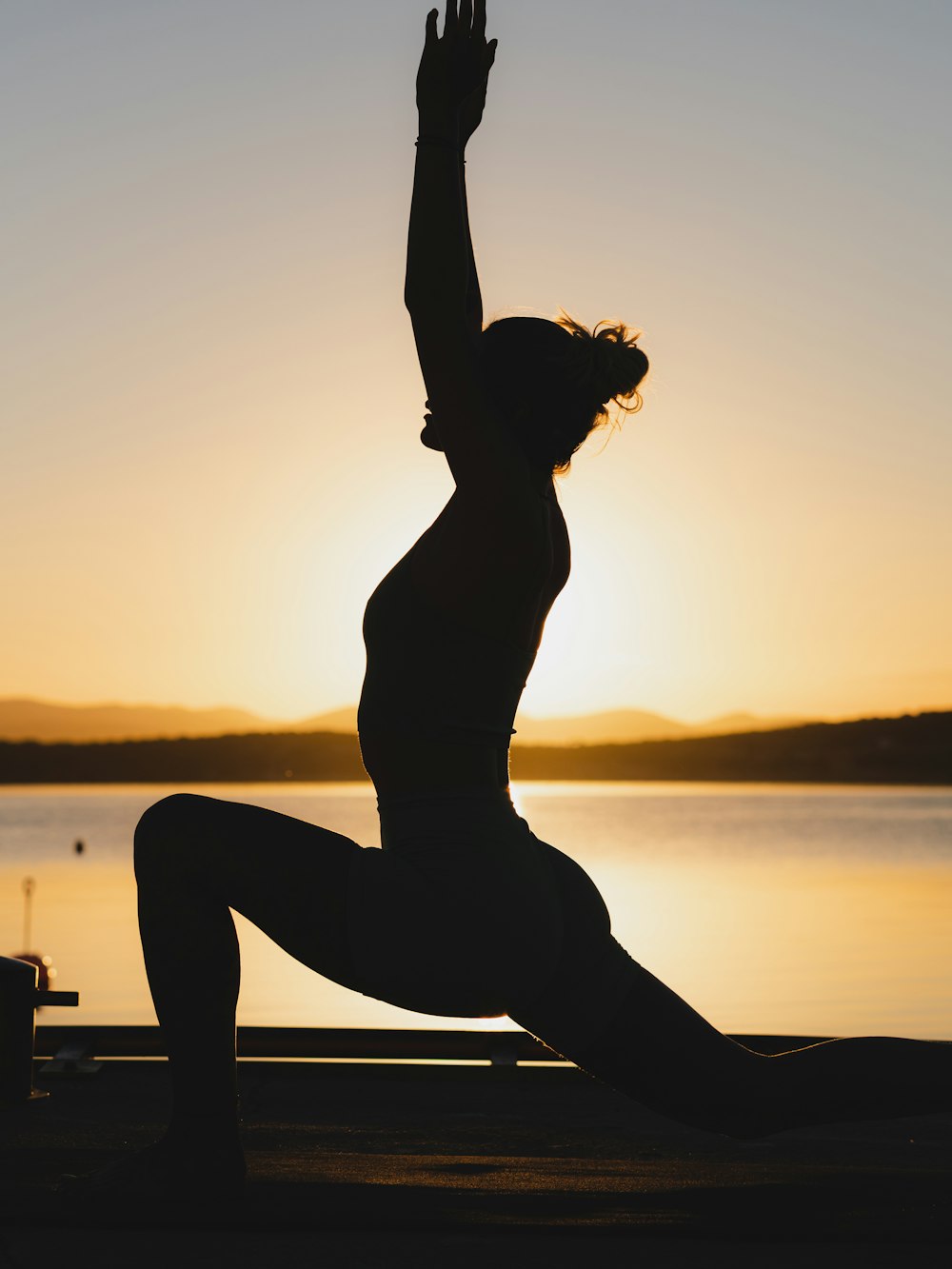 A student in a low lunge, lit softly from the side